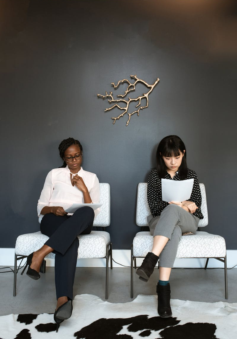 Two women sitting in an office, preparing for interviews.