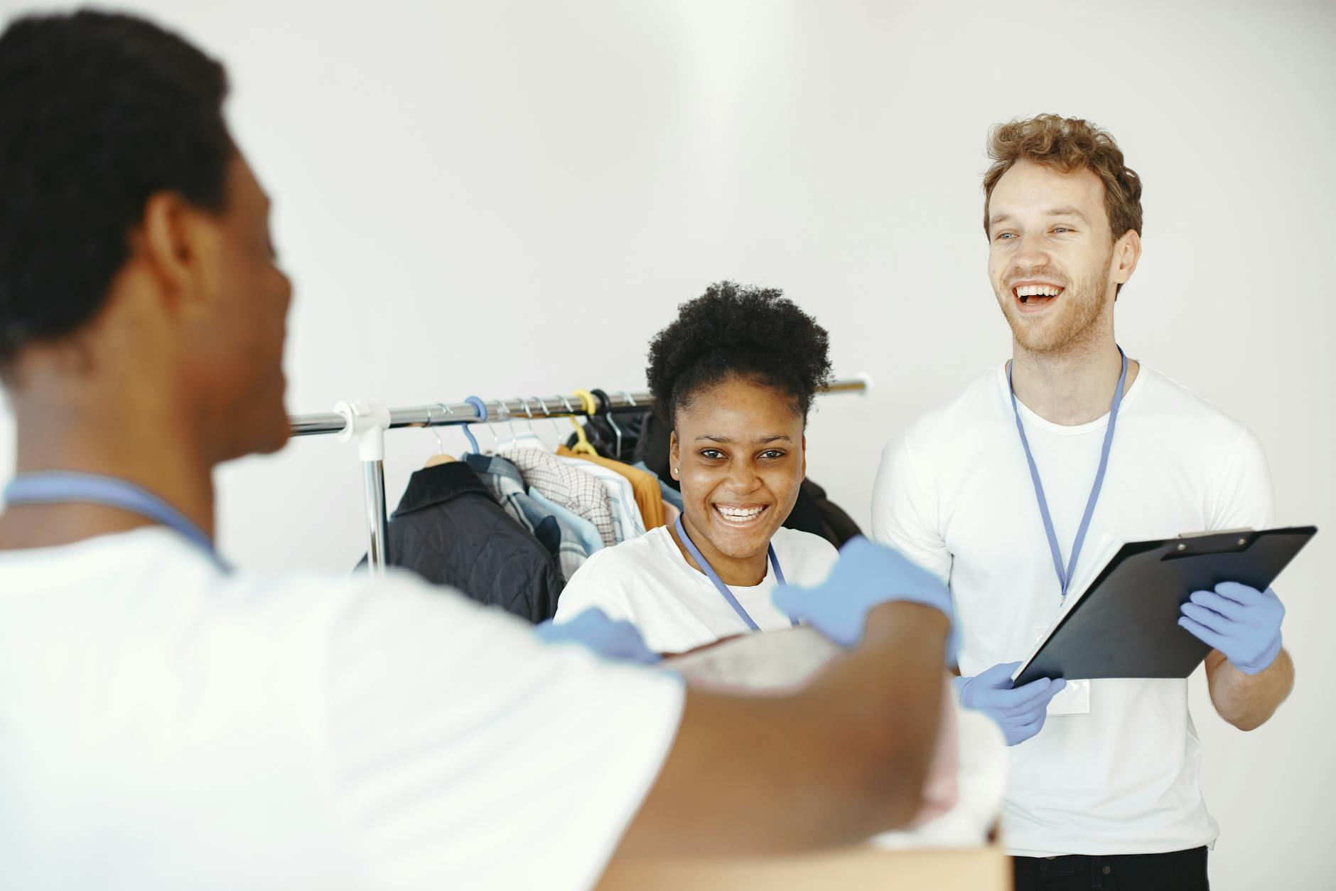 Happy volunteers organizing donated clothes, showing teamwork and collaboration in a community effort.